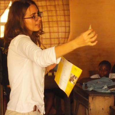 Students at a school in Africa listen to a talk about basic rights given by a student doing a Human Rights internship abroad.